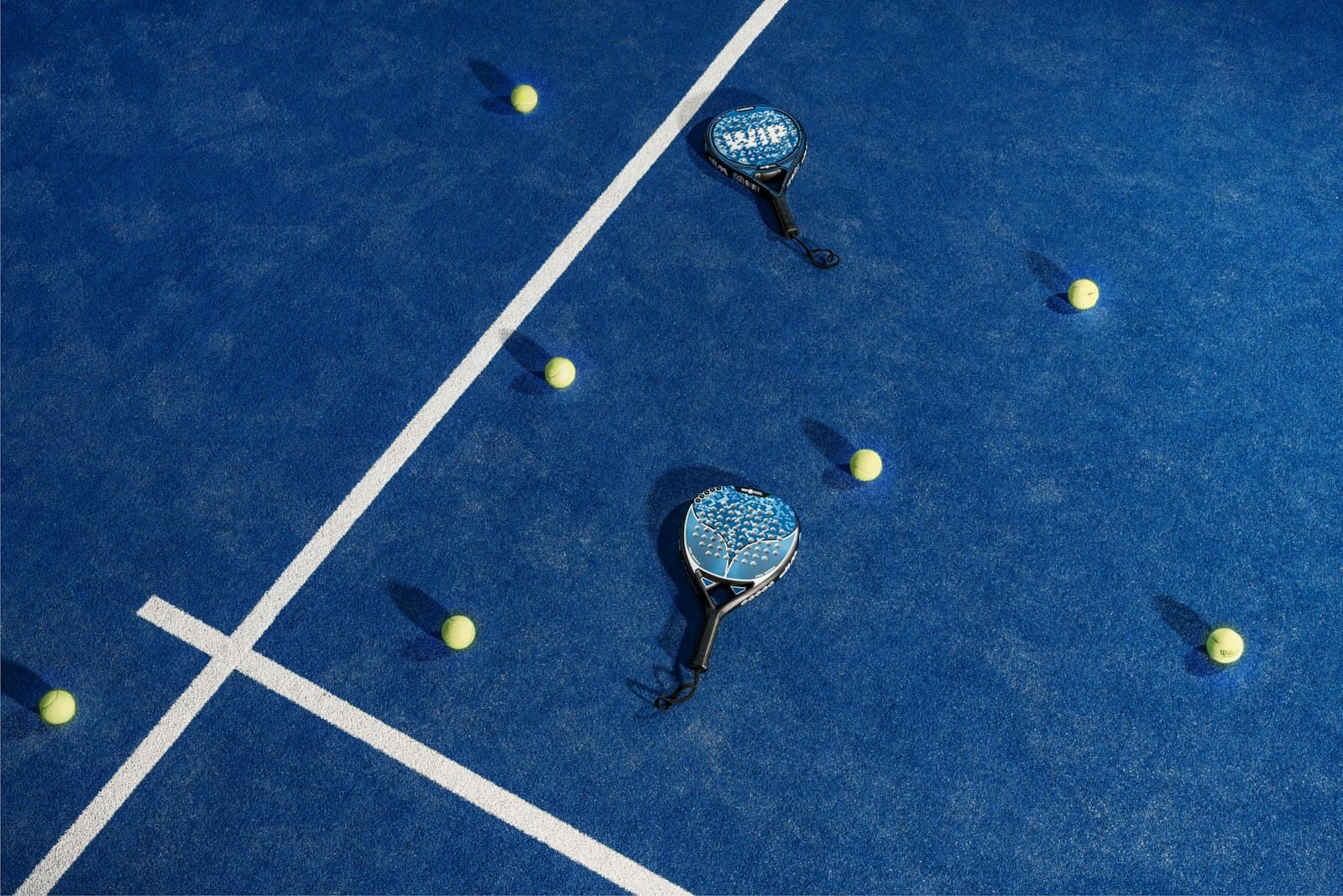 Padelracketar och bollar på en padelbana